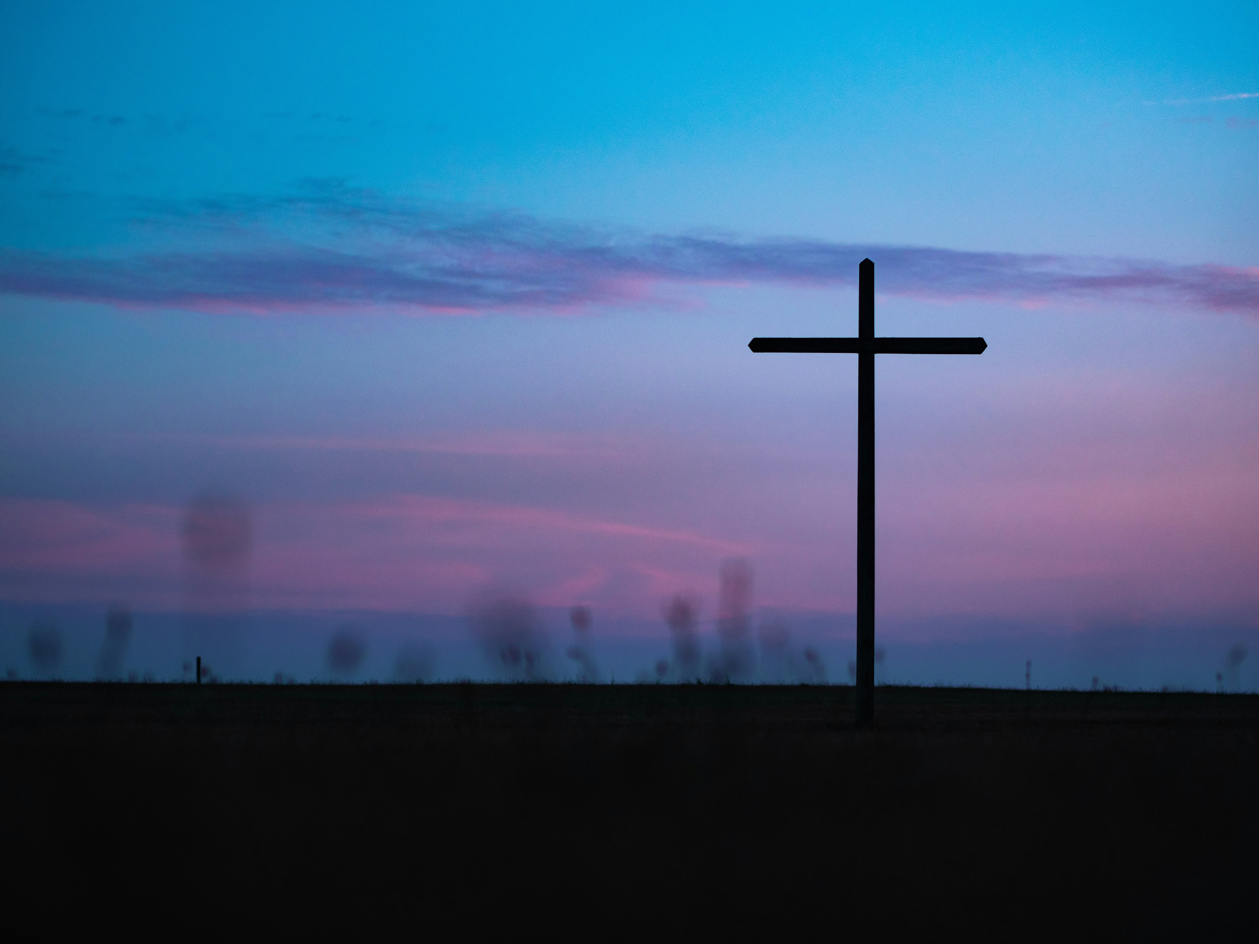 Cross before a colourful horizon