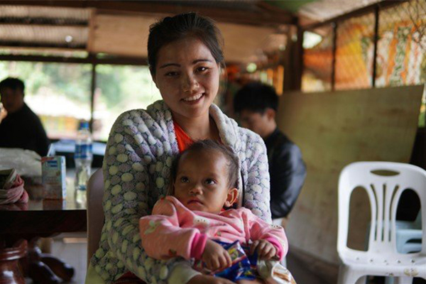 South-East Asian woman smiling, and baby